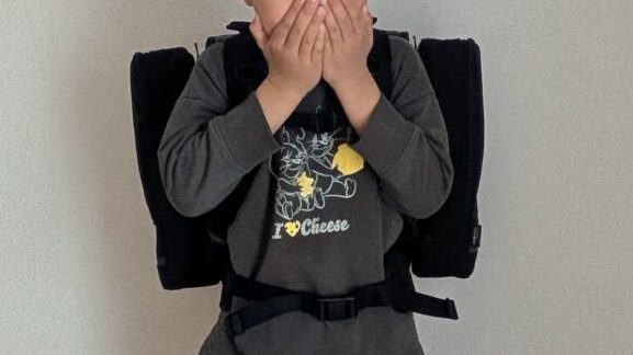 拡張ポーチを付けたエルゴランセルを小1男の子が笑顔で背負っている写真